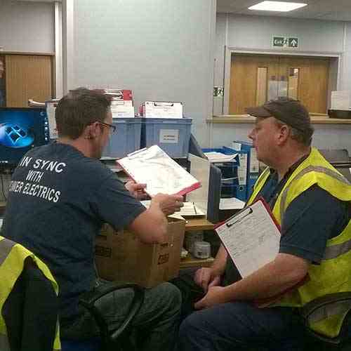Power Electrics workers discussing schedule for the day