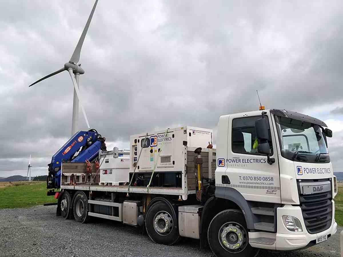 Generator on lorry with wind turbine in the background